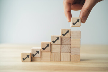 Poster - Wooden blocks forming ascending graph, hand placing top block, symbolizing growth, progress, and success in business or personal development