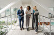 © Maria Vitkovska - Business people walking and talking in modern office hallway