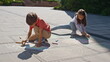© stockbusters - Brother sister drawing crayons sunny street. Little children creating pictures