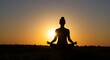 © Pambudi - Silhouette of a person meditating in a yoga pose during sunrise, symbolizing inner peace, mindfulness, and spiritual balance in a calm natural setting.