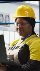 Poster - vertical video woman working in industry 4.0 plant using notebook, following maintenance procedures.