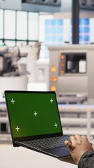 Poster - vertical video factory engineer typing on green screen laptop, monitoring production lines. woman in