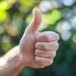 © Akbar Zeynalli - A close-up of a hand giving a thumbs-up, the hand with a thumb raised, signaling approval and positivity