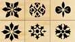 © Володимир Виповський - Six intricate black stencil designs on light wooden square tiles...