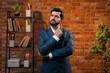 © StockImageFactory - Pensive Indian entrepreneur in corporate attire thinking with folded arms in cozy office