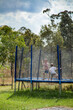© Austockphoto - Two boys jumping on the trampoline in the rain