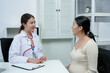 © Ekkasit A Siam - Asian pregnant adult woman consulting with female doctor in white coat during medical appointment discussing prenatal care planning childbirth expressing trust connection health support motherhood
