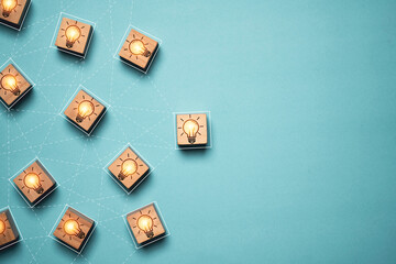 Poster - Glowing light bulb linkage on wooden block cube with copy space for brainstorming to creative thinking idea and problem solving concept.