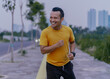 © PRIYO DWI SAPUTRO - Asian man jogging in the park. Fitness Man Running, Training Run Workout.