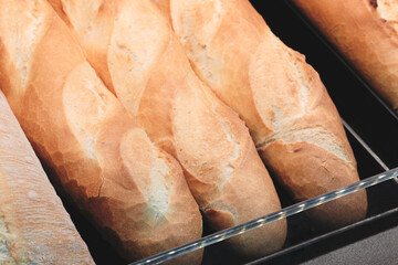 Poster - A display of bread with a variety of shapes and sizes. The bread is arranged on shelves and is ready to be sold.