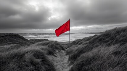 Poster - Red flag is flying in the wind on a beach. The flag is on a pole and is in the foreground. The beach is empty and the sky is cloudy. The flag is the only thing in the scene