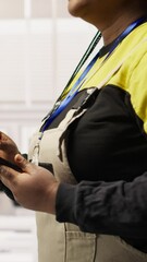 Poster - vertical video engineer in smart factory oversees robotic assembly lines using tablet app, ensuring 