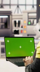Poster - vertical video factory engineer typing on green screen laptop, monitoring production lines. woman in