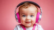 © Jim Middlewoods - A little baby girl wearing headphones listening to music. Smiling at camera. Abstract pink background.