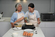 © zasabe - Two women, daughter cooking with elderly mother at home, happy mother's day, family day