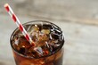 © New Africa - Refreshing cola with ice cubes and straw in glass on blurred light background, closeup. Space for text