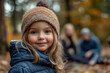 © Tetiana - Adorable child in a Cozy Winter Hat Enjoying an Autumn Picnic with Family in a Scenic Forest Camping Adventure, generative ai