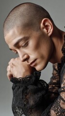 Poster - A thoughtful androgynous model rests their chin on clasped hands, highlighting the striking elegance of lace sleeves against a soft background. The moment conveys deep introspection.
