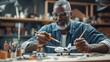 © Hungarian - A mature craftsman meticulously paints a model airplane in a workshop.