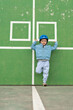 © Elena - Stylish young boy in a blue helmet and jacket leans confidently against a green sports wall. Minimalistic composition and urban vibe make it ideal for childrens fashion, lifestyle, or sport ads.