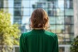 © DesignDepot - Seen from behind middle aged woman employee near office building in green blouse.