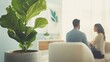 © hkjdesign - A fiddle leaf fig plant in focus in the foreground, with a blurred background of a couple in therapy.