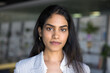 © fizkes - Head shot profile picture beautiful self-assured Indian businesslady look at camera standing alone in workspace. Close up portrait woman office employee exuding success, competence and professionalism