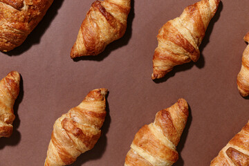 Wall Mural - many tasty croissants on brown background