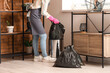 © Pixel-Shot - Woman taking garbage bag from trash bin at home