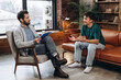 © Maria Vitkovska - Smiling teenage boy talking with male psychoanalyst during therapy session