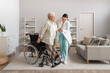 © Pixel-Shot - Physical therapist helping senior woman to stand up from wheelchair at home