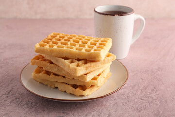 Wall Mural - plate with delicious belgian waffles and cup of tea on pink background