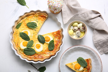 Wall Mural - cut easter egg tart with spinach leaves and sweet cake on white background