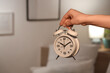 © Pixel-Shot - Female hand with alarm clock in bedroom at night, closeup