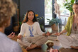 © Rido - Mixed race woman practicing meditation at yoga class