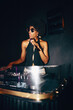 © Jacob Lund - DJ performing at a nightclub spinning music with a stylish appearance