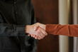 © Westend61 - Close-up of a handshake between two business professionals indoors