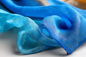 Poster - Elegant blue silk fabric draped artistically on a smooth surface showcasing delicate textures and vibrant hues