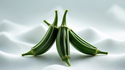 Poster - Three fresh green okra pods, small size, prepared for cooking on a white background