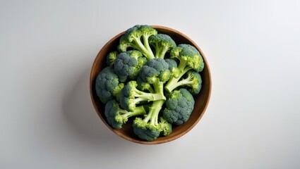 Aufkleber - Top view of organic broccoli in wooden bowl on white background