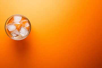 Poster - A single glass filled with clear water and ice cubes rests on a striking orange background, creating dynamic shadows and an eye-catching contrast