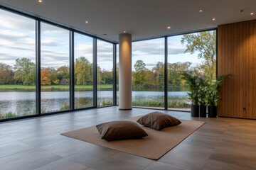 Poster - A spacious living area features large glass windows with a view of a calm lake, showcasing a minimalist style with cushions on a low bench and soft lighting