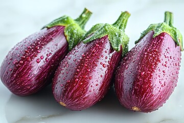 Poster - Freshly washed eggplants gleam with droplets on a light surface, ready for the kitchen preparation