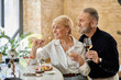 © LIGHTFIELD STUDIOS - Romantic evening for a mature couple enjoying wine and appetizers at a cozy restaurant