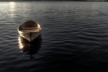 Poster - Stillness of an old boat resting on a calm lake at dusk surrounded by nature's beauty