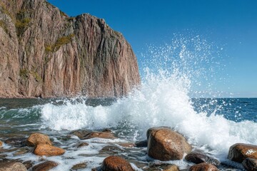 Aufkleber - Waves crashing against rocky shore beneath towering cliffs on a clear sunny day