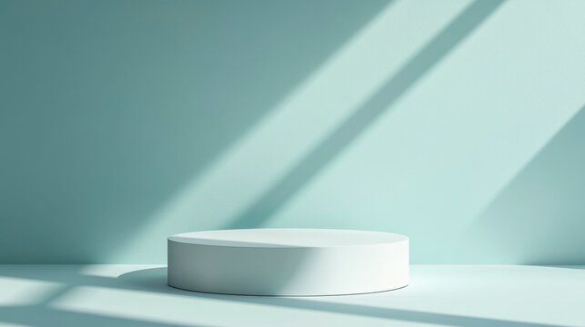 Minimalist white cylindrical podium on light teal background with sunlit shadows.