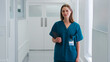 © Monkey Business - Portrait Of Smiling Female Doctor Wearing Scrubs In Hospital Corridor Holding Digital Tablet