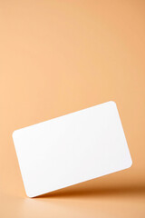 Poster - Blank white card lies on peach background. Card is clean and smooth. Simple rectangle shape with rounded corners offers space for message, invitation, or announcement.