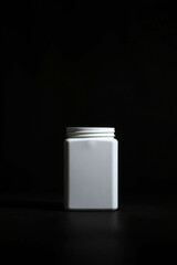 Aufkleber - White container on dark background. Plain container with closed lid. Simple shape with light color. Storage object for different products. Empty box stands alone on surface.